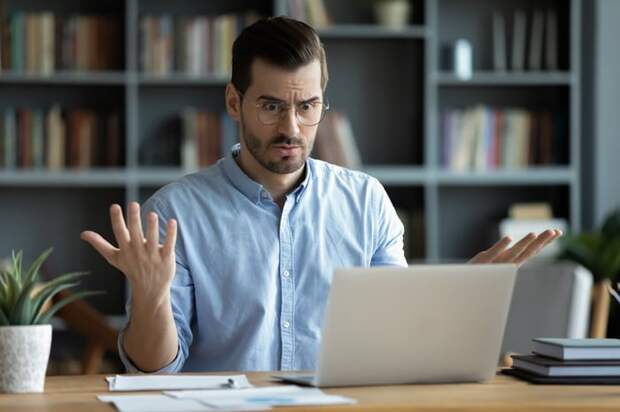Confused person looking at a laptop.
