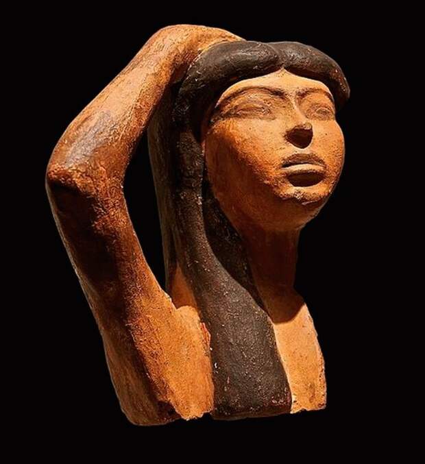 Редкий образец египетской терракотовой скульптуры изображает Изиду, оплакивающую Осириса. Скульптура изображает женщину, поднимающую правую руку над головой, типичный траурный жест. (Лувр / Общественное Достояние)
