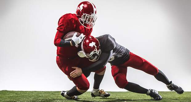 a computer generated image of a football player tackling another football player holding the football