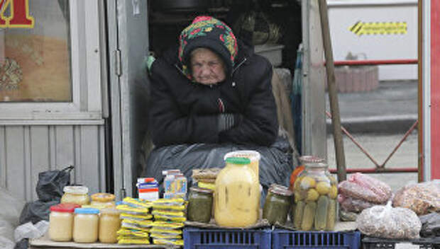 Пожилая женщина торгует на улице в Киеве