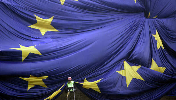 Рабочий закрепляет на фасаде здания флаг Евросоюза. Архивное фото