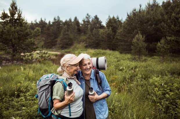 Two adults in a field with arms around each other.