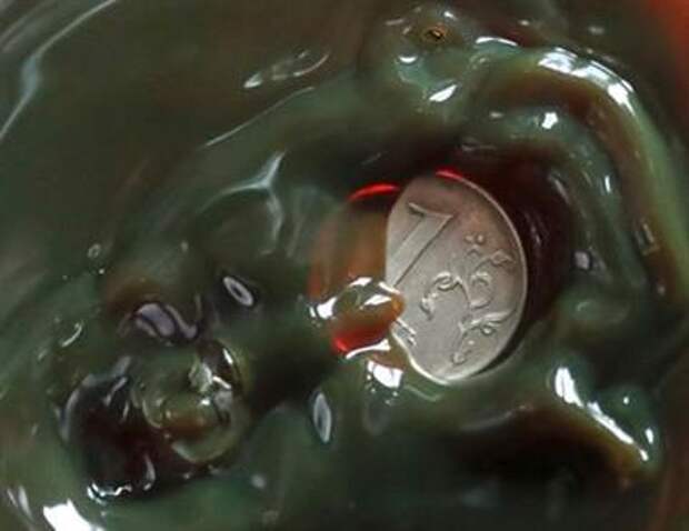 A view shows a one Russian rouble coin inside a bulb with crude oil at a laboratory in the Yarakta Oil Field, owned by Irkutsk Oil Company (INK), in Irkutsk Region, Russia in this picture illustration taken March 12, 2019. Picture taken March 12, 2019. REUTERS/Vasily Fedosenko/Illustration 