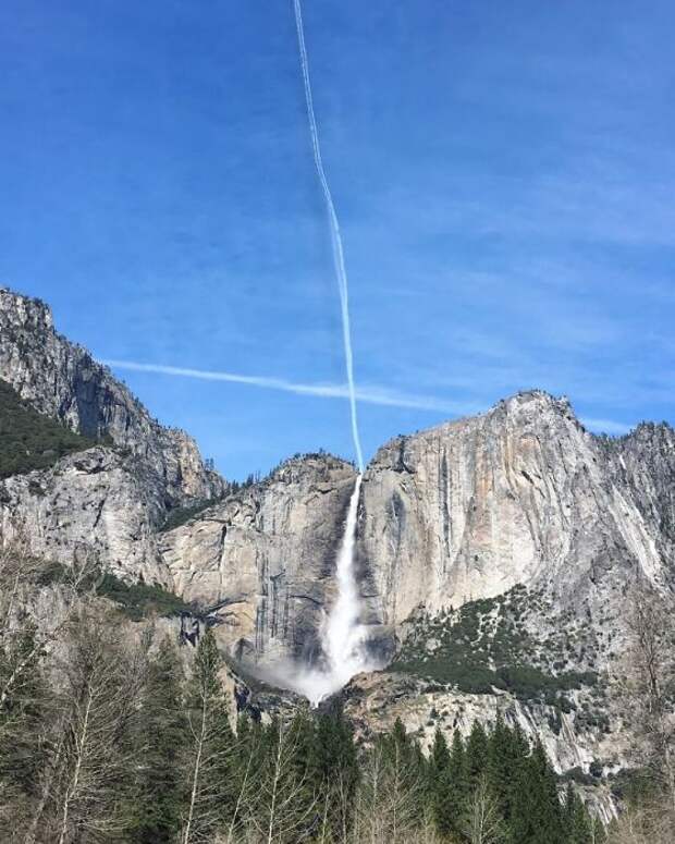След от самолета выглядит как низвергающаяся с неба вода, которая превращается в водопад.