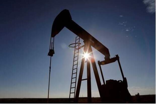 FILE PHOTO: The sun is seen behind a crude oil pump jack in the Permian Basin in Loving County, Texas, U.S., November 22, 2019. REUTERS/Angus Mordant/File Photo