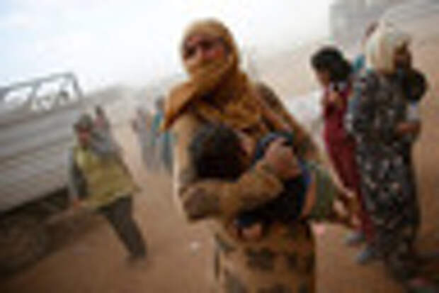 A Kurdish Syrian refugee waits for transport during a sand storm on the Turkish-Syrian border near the southeastern town of Suruc in Sanliurfa province, September 24, 2014. The United Nations refugee agency said on Tuesday it was making contingency plans in case all 400,000 inhabitants of the Syrian Kurdish town of Kobani fled into Turkey to escape advancing Islamic State militants.           REUTERS/Murad Sezer (TURKEY  - Tags: POLITICS TPX IMAGES OF THE DAY CIVIL UNREST CONFLICT)   - RTR47JGB