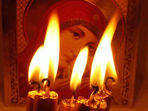 Зажженные свечи перед иконой во время молитвы