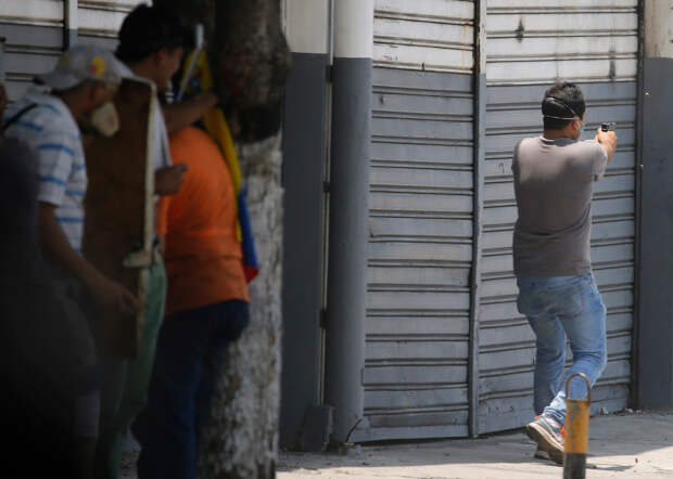 Оппозиционер стреляет из пистолета по силам правопорядка, Каракас