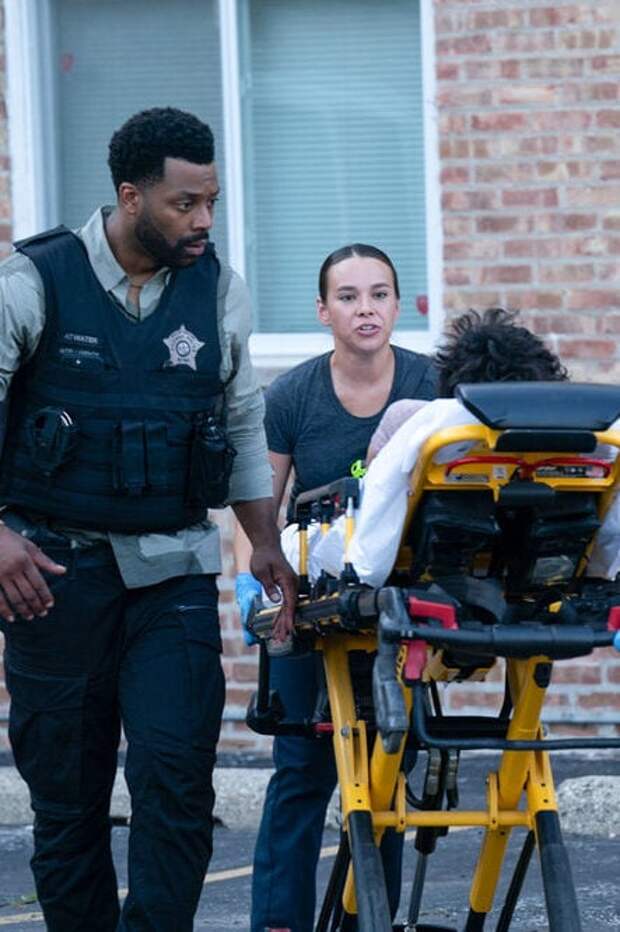 Atwater walks beside a victim he rescues in Chicago PD Season 12 Episode 3.
