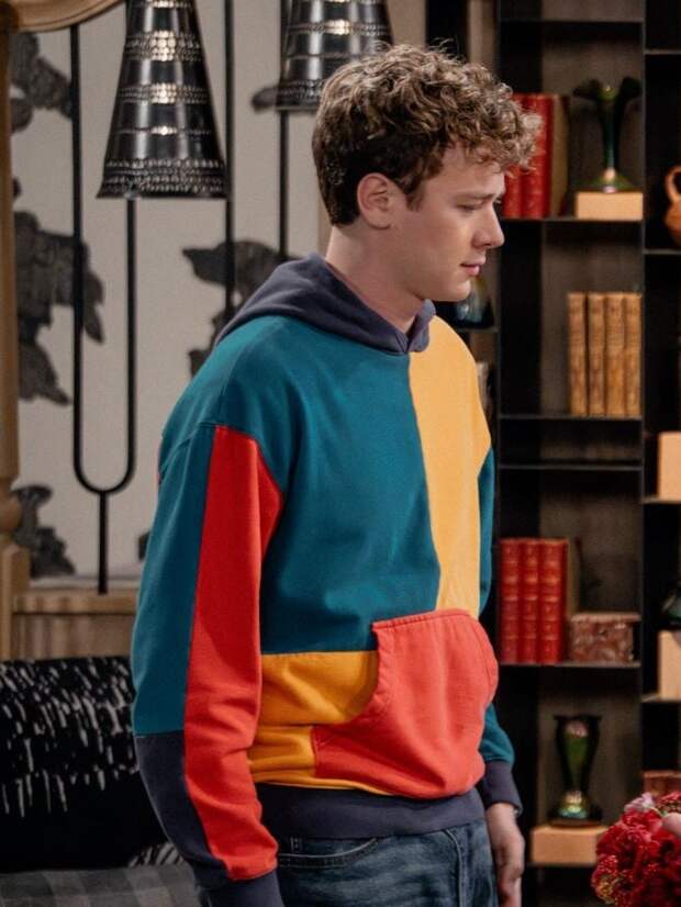 David Crane stands wearing a colorblock hooded sweatshirt