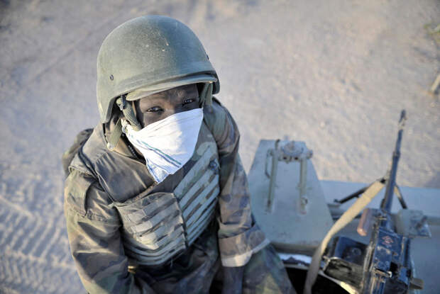 Солдат Уганды сидит наверху своего бронированного транспортного средства