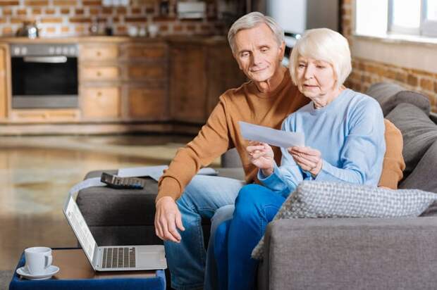 Older couple holding a check. 