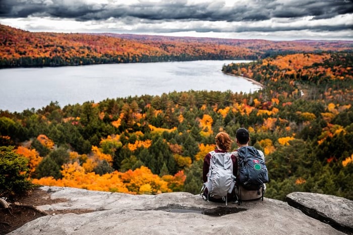 Couple overlooking view of fall foliage.