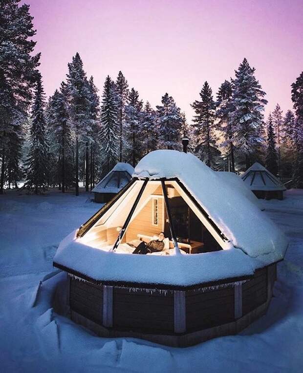 Заснеженный домик с прозрачной крышей в Саариселькя, Финляндия.