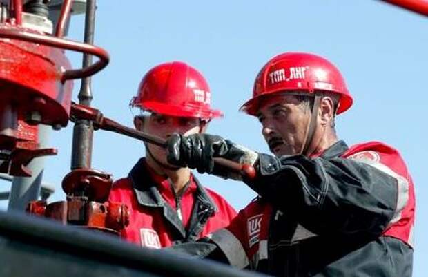 File photo of Russian workers of the Russia's oil major LUKOIL oil refinery near the town of Kagalym in western Siberia. File photo of Russian workers of the Russia's oil major LUKOIL oil refinery near the town of Kagalym in western Siberia are pictured, July 7, 2004. Announcement of the agreement, which Russia's oil major LUKOIL and the third largest U.S. firm ConocoPhillips said enjoyed the strong support of the U.S. and Russian governments, followed the purchase at auction by Conoco of Russia's remaining 7.6 percent stake in LUKOIL for $1.998 billion. File photo taken July 7,2004. REUTERS/Viktor Korotayev