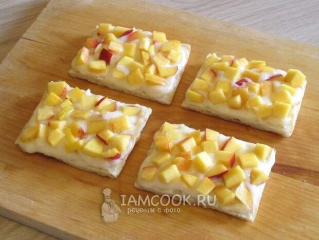 Смазать заготовку кремом и положить кусочки нектарина