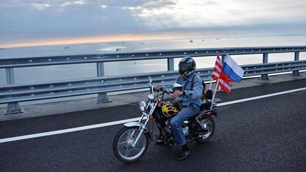 Мотоциклист едет по автодорожной части Крымского моста