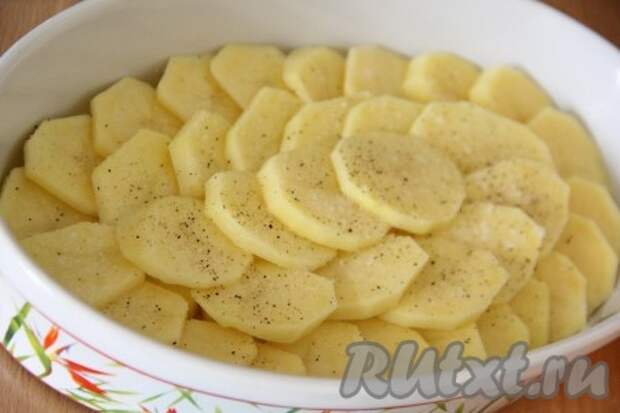 В жаропрочную форму выложить картофель. Я выкладывала картофельные кружочки внахлёст. Слегка посолить и поперчить картошку.  