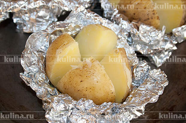 Картофель, запеченный с сыром и каперсами За 5 минут до готовности картофеля вынуть его из духовки. Снять сверху фольгу, нарезать каждый клубень на четыре части, не прорезая до конца.
