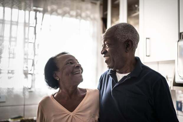 Smiling couple standing in their kitchen.
