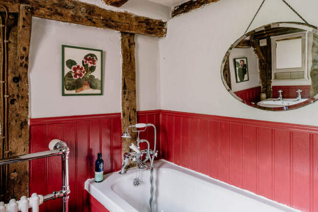 Малиново-розовые панели, обрамляющими стены и встроенную ванну придают комнате свежести.