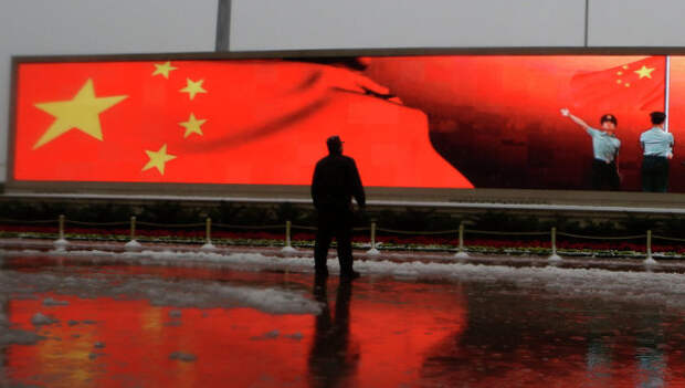 Человек на фоне экрана с флагом Китая, Пекин. Архивное фото