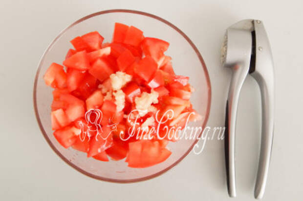 Перекладываем измельченные томаты с миску и добавляем к ним пару зубчиков свежего чеснока, который нужно очистить и измельчить (с помощью пресса или просто ножом)