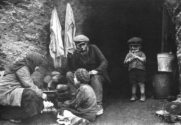 Советские беженцы за приготовлением еды у входа в землянку. Белоруссия. 1944 г.