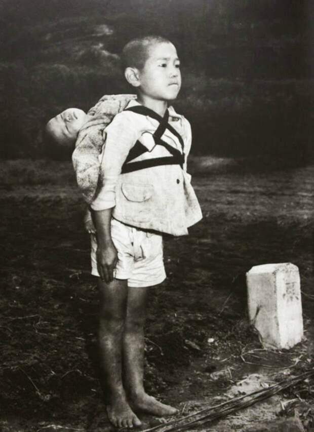 A-Japanese-boy-standing-at-attention-after-having-brought-his-dead-younger-brother-to-a-cremation-pyre-1945.jpg