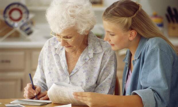 ca. 2000 --- Woman and Grandmother Paying Bills --- Image by © Jose Luis Pelaez, Inc./CORBIS