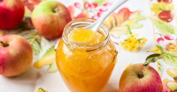 Apple jam in a jar and fresh red apples