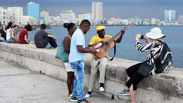 Кубинцы и туристы отдыхают на набережной Малекон в Гаване