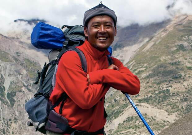 Шерпа (портер) помогает туристам покорять Эверест 