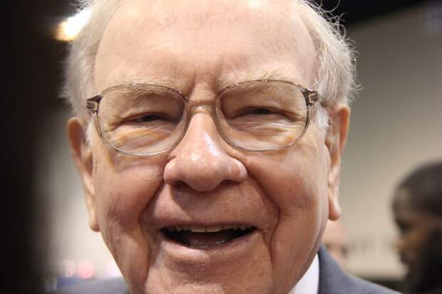 Warren Buffett looking into the camera smiling.