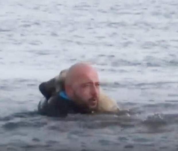 Мужчина тащит собаку