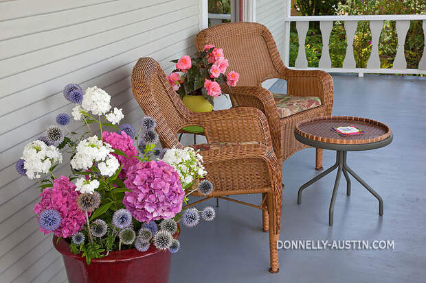 Vashon-Maury Island, WA Two wicker chairs on porch with summer flowers
