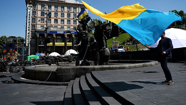 Молодой человек с украинским флагом у памятника основателям Киева на площади Независимости. Архивное фото