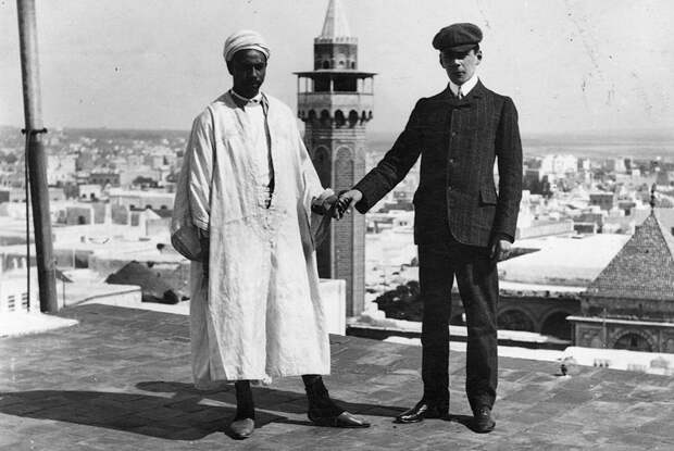 Турист с гидом позируют на открытой террасе в Тунисе. 1908 год.