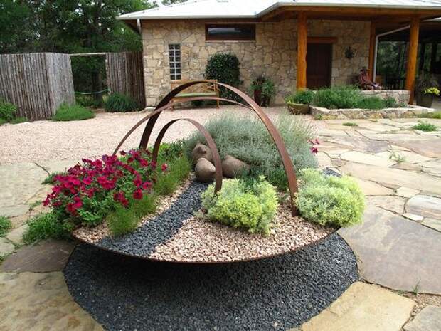 old barrel rings and what is that bowl? nice with the paving stones. no lawn anywhere.: 