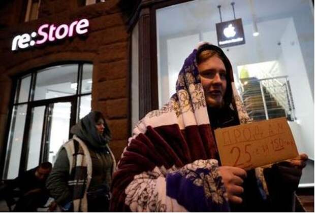 A man holds a sign about selling his place in line before the Apple's new iPhone XS and XS Max go on sale in front of a cell phone store in central Moscow, Russia September 26, 2018. REUTERS/Tatyana Makeyeva