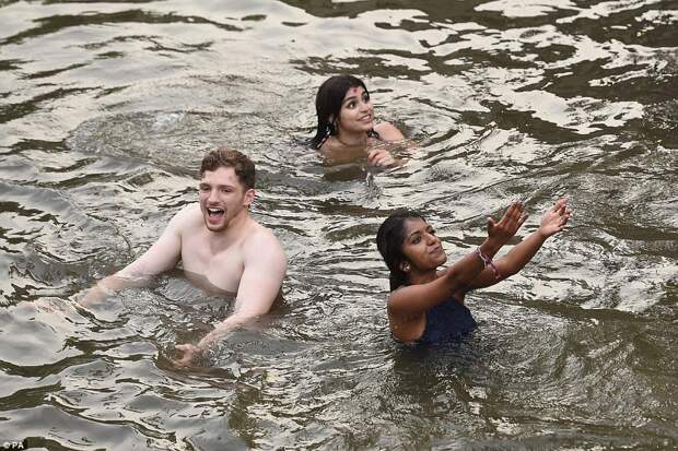Three guests wave to their friends after diving into the river at the end of the evening's festivities in Cambridge