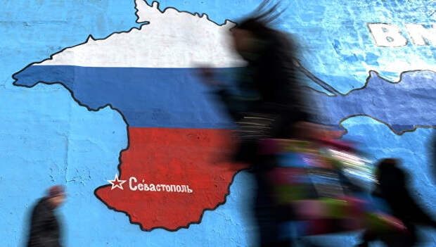 Прохожие у нарисованной на стене карты Крыма в цветах российского флага в Москве. Архивное фото