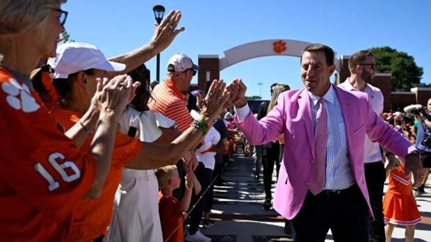 Dabo Swinney high fives Clemson fans as he walks to Memorial Stadium.