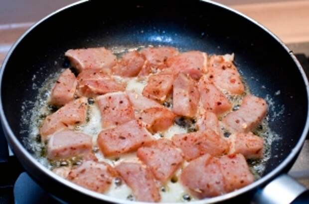 На сковородку выкладываем оставшееся масло и обжариваем в нём мясо 10 минут.
