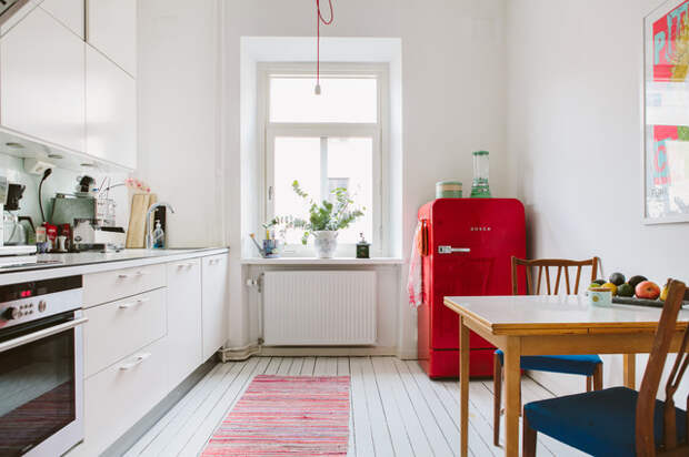 Интерьер маленькой кухни с холодильником необычного цвета. 