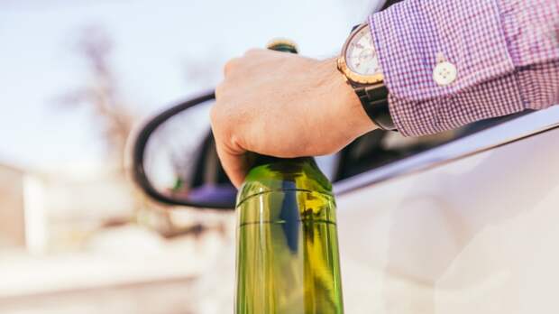 man drinking alcohol while driving the car