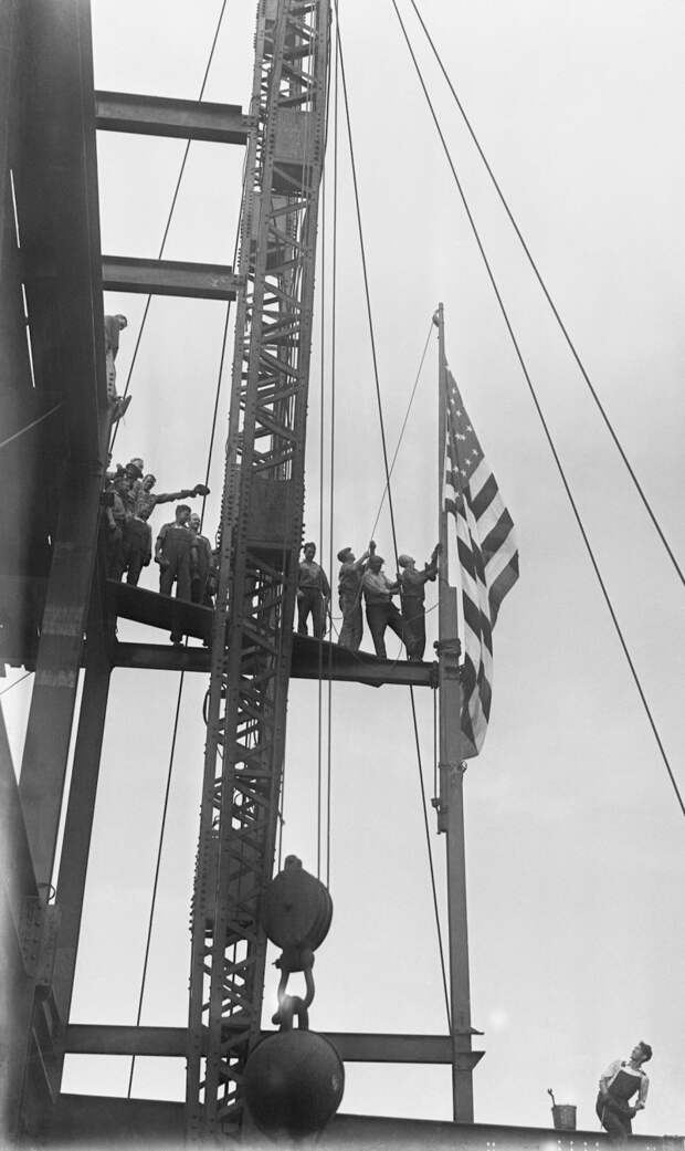 14. Рабочие на церемонии поднятия флага на строящемся Empire State Building. Это была самая высокая точка в городе, на которой когда-либо поднимали флаг. Высота — 319 метров над землёй. Сентябрь 1930 года. история, небоскрёбы, фото