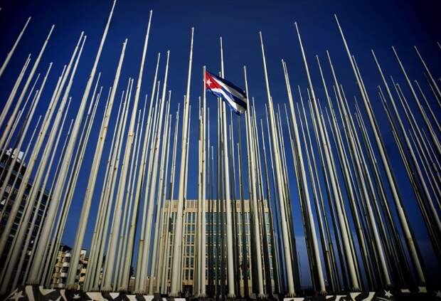 Кубинский флаг перед зданием посольства США в Гаване, Куба