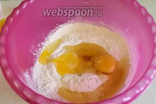 Муку высыпать горкой в миску, посолить, добавить 2 яйца.