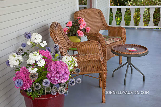 Vashon-Maury Island, WA  Two wicker chairs on porch with summer flowers